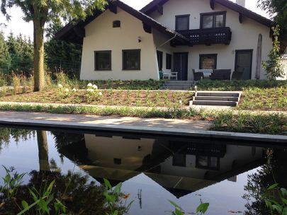 Aangelegde tuin met oudhollandse klinkers en betonmaterialen met zwemvijver - Neerpelt